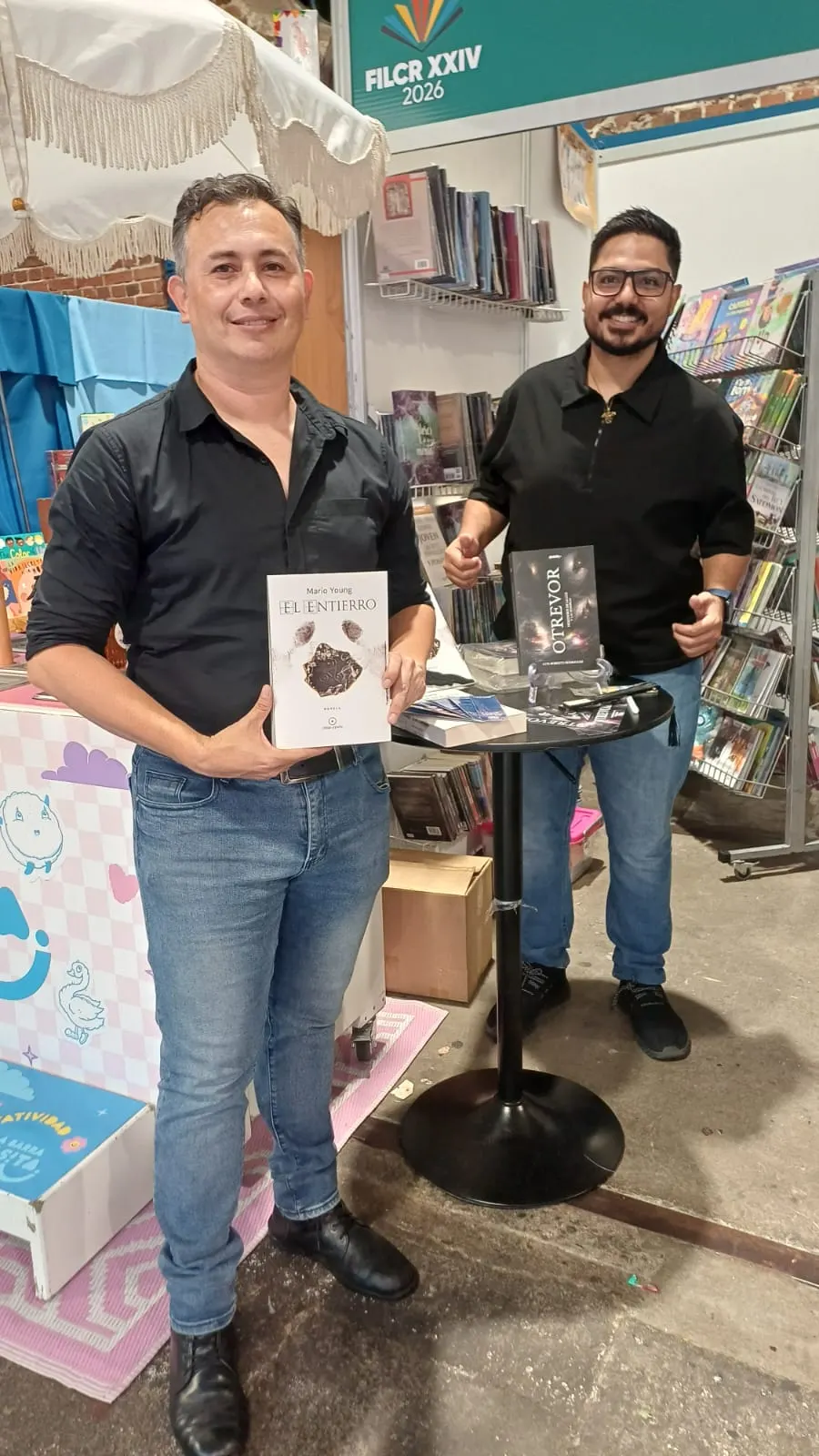 Mario Young junto al autor Luis Roberto Rodríguez en el stand de Tribu Literaria en la FIL 2026